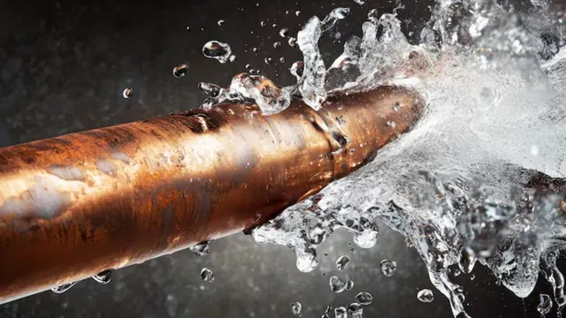Water spraying from a split copper pipe.